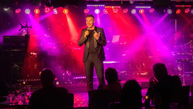 jonny wilkes on stage pink lights behind him