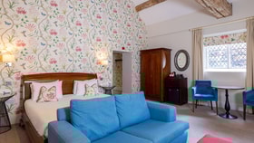 Large bedroom with blue and pink accents and dark wood furniture