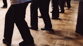 A group of people's legs as they dance in a line