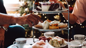 Guests reach for delicious festive treats off of the afternoon tea stand