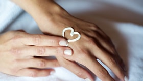 Close up of a person's hand with a heart drawn with cream