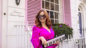 Philippa Healey wearing sunglasses and playing a keytar
