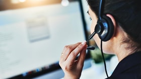 Woman in a call center with a headset in front of a computer