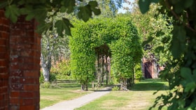 An archway made by carved trees in the garden grounds at Gunton Hall