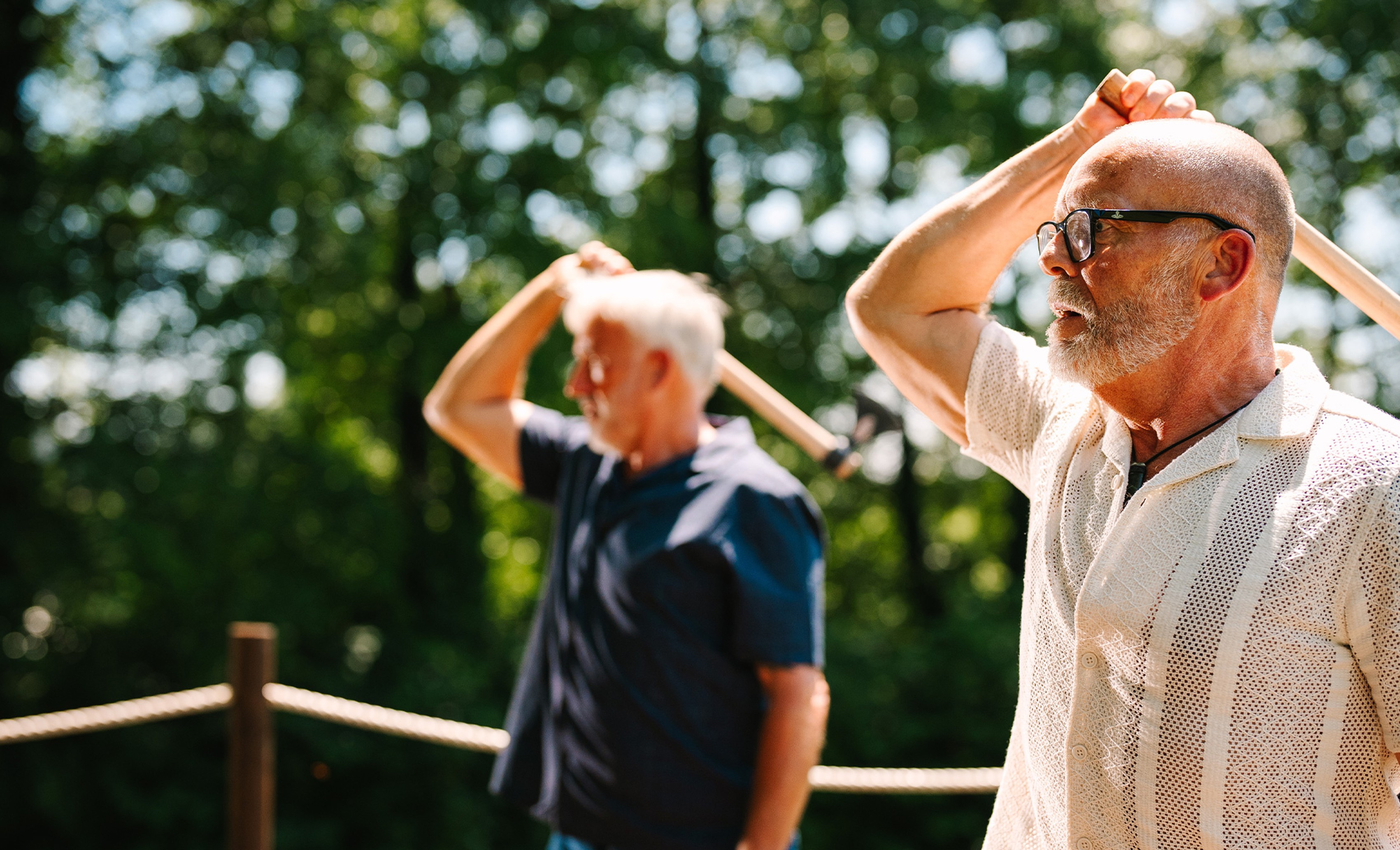 Two men throwing axes in a field