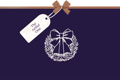 Minimalist festive graphic with a deep purple background, featuring a white line illustration of a wreath with a bow. A gift tag tied with a brown ribbon reads ‘The Artful One’