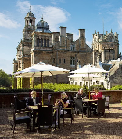 Guests on the terrace at Thoresby Hall having drinks from the Coffee Nest in the summer sun