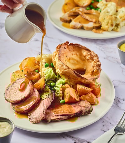 Roast beef dinner with gravy being poured all over