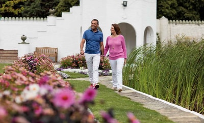 Couple walking on a sunny day through the walled garden.