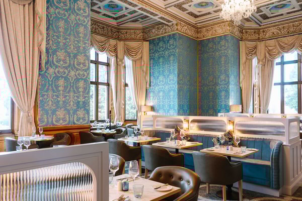 Savour every bite in the elegant Blue Room at Brasserie32 - a space designed to delight, from the table to the intricate ceiling above.