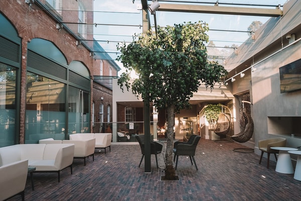 Welcome to tranquillity. The Spa reception at Studley Castle features a serene courtyard with a beautiful tree, perfect for unwinding before your pampering session.