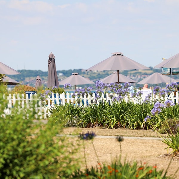 Vibrant gardens bursting with colourful flowers surround the outdoor pool, adding to the already picturesque views.