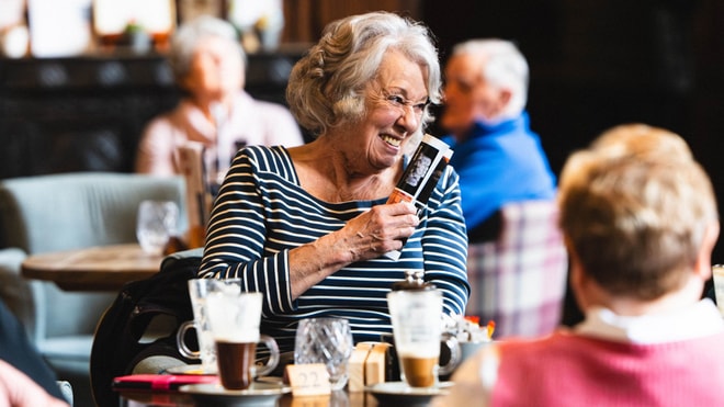 A hotel guest laughing at a table with others during a BBC History Magazine weekend event.