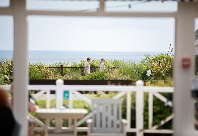 Guests walking along the seafront at Corton