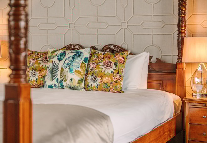 Close up of a comfy bed with colourful throw pillows