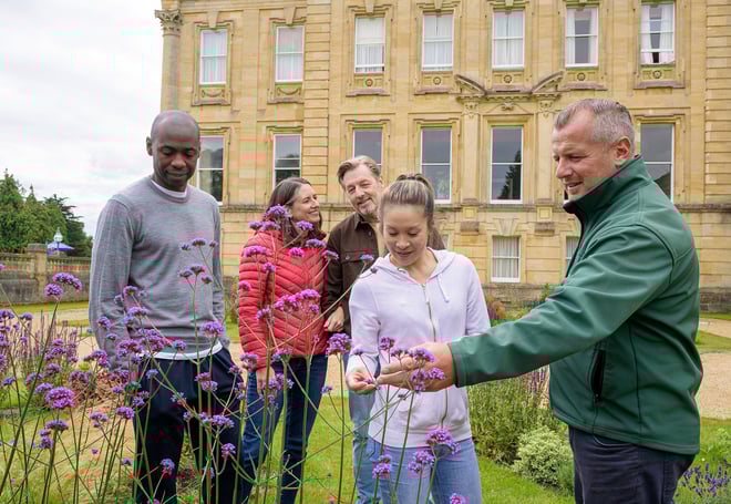 Guests having a tour of the gardens and grounds at Heythrop Park, lead by one of the grounds keepers