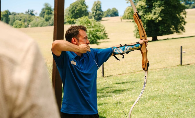 Warner team member teaching archery