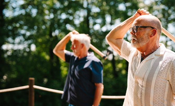 Two men throwing axes in a field