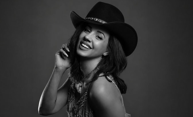 Black and white photo of Ami Vaziri in a cowboy hat