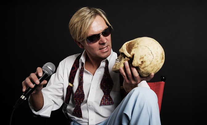 Bootleg Bowie staring at a skull in his hand with interest