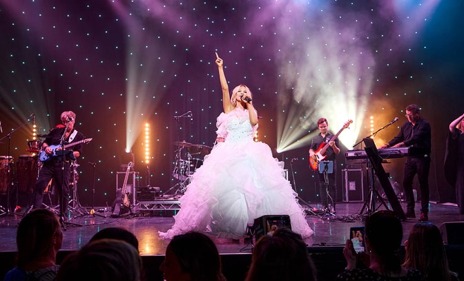The Celine Experience performing in white dress