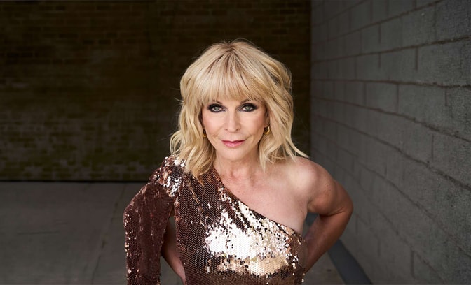 Toyah standing in front of brick wall
