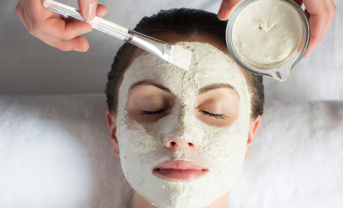 Woman's face with a thick face mask being applied