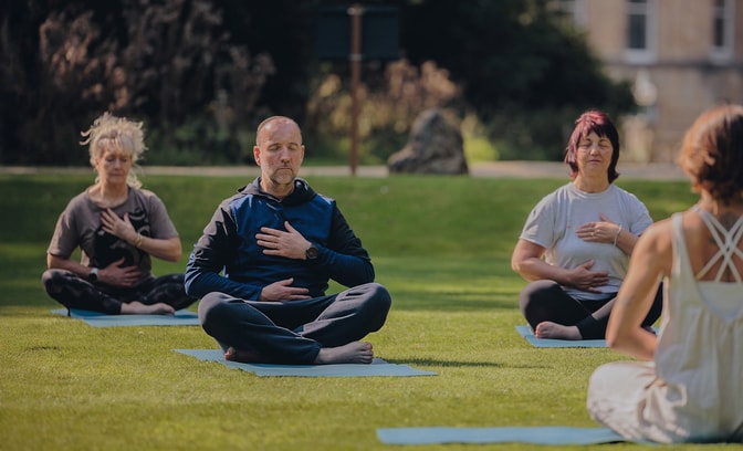 Group of people enjoying a guided meditation in the sun