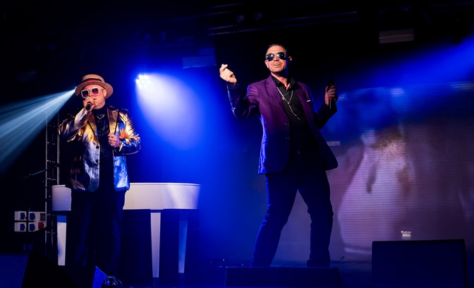 Russell Keith as George Michael, Adam Rose as Elton John