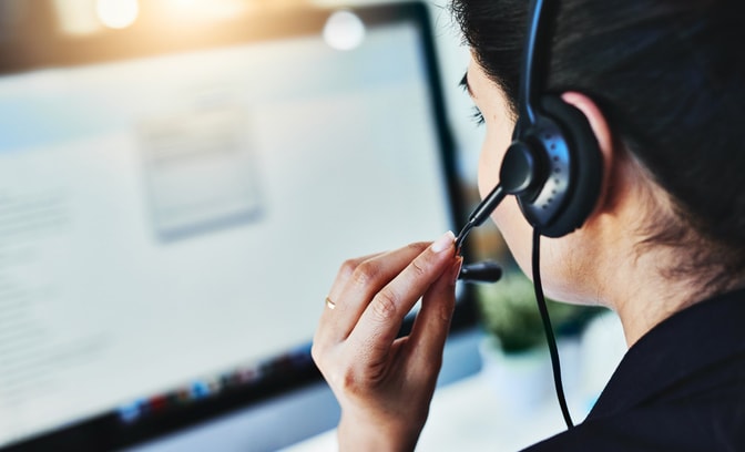 Woman in a call center with a headset in front of a computer