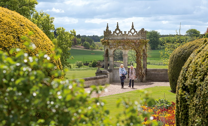 Two guests wandering through the beautiful gardens at Thoresby Hall Hotel