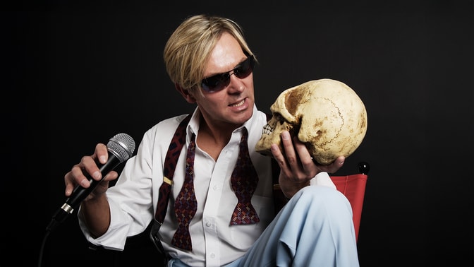 Bootleg Bowie staring at a skull in his hand with interest