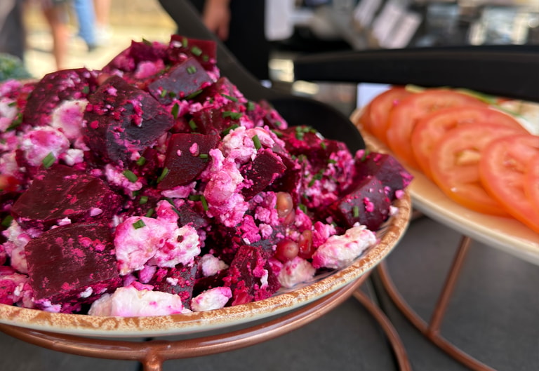 Close-up of a vibrant beetroot salad with crumbled cheese and herbs, served as part of a Big Green Egg dining selection.