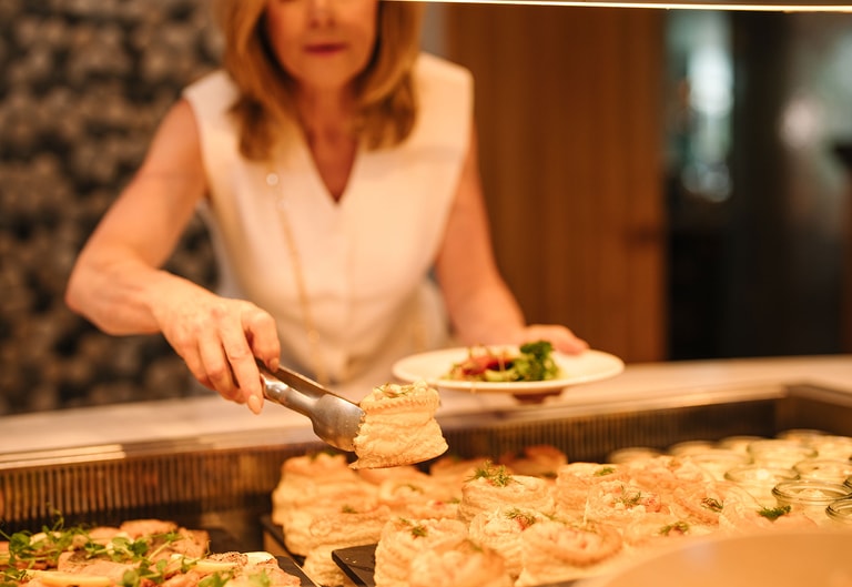 Guest choosing freshly prepared dishes from buffet