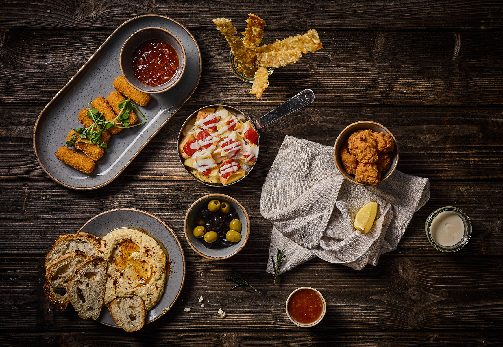 aerial view of some small plates including croquettes, hummus and crudites and more