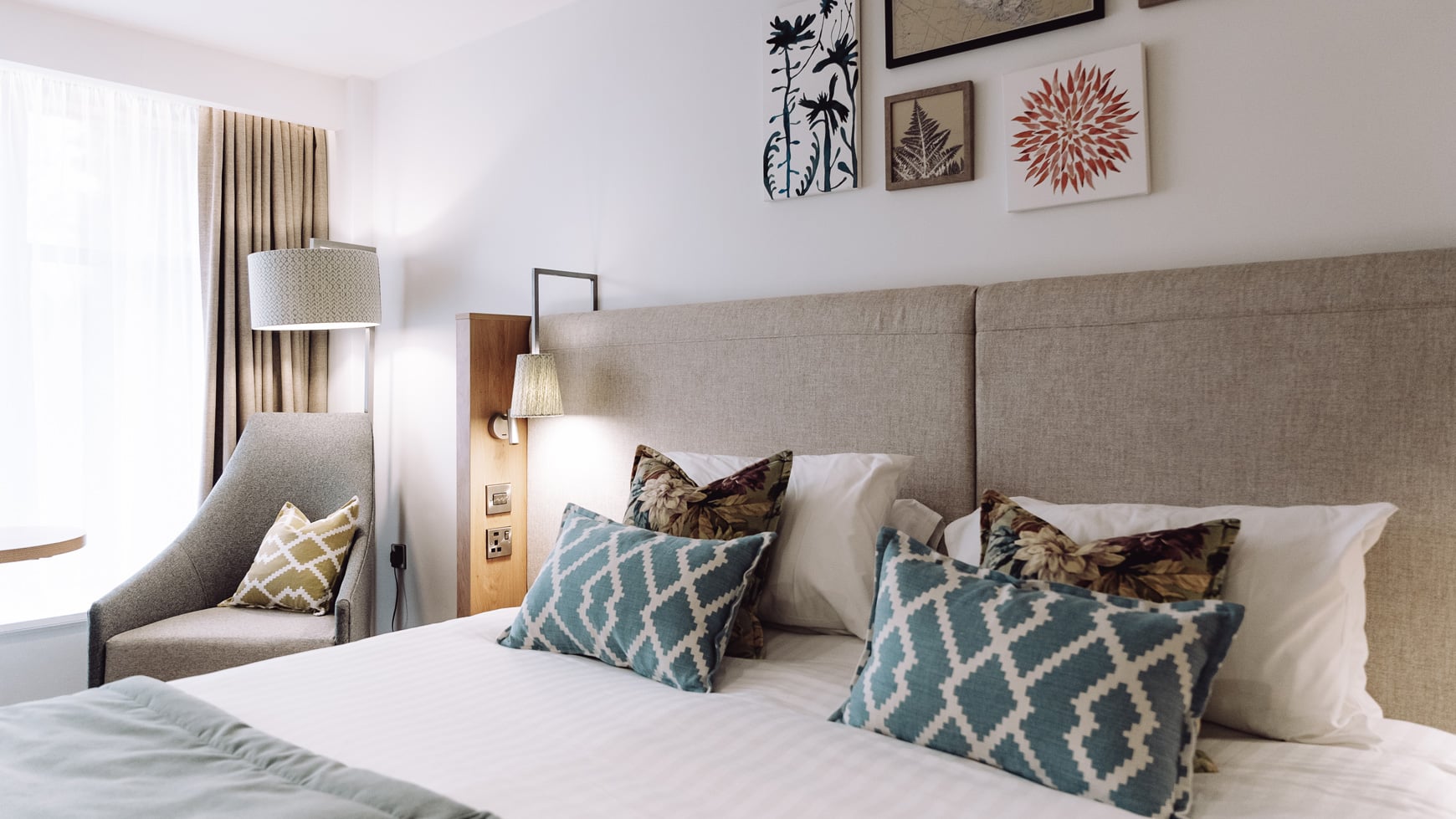 Close up of a double bed with patterned throw pillows