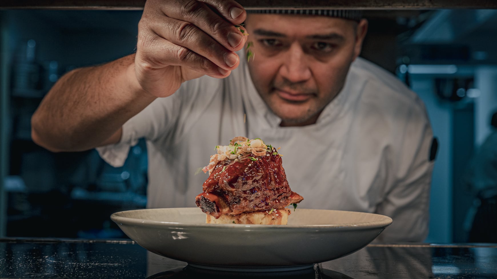 A chef putting the finishing touches on a dish
