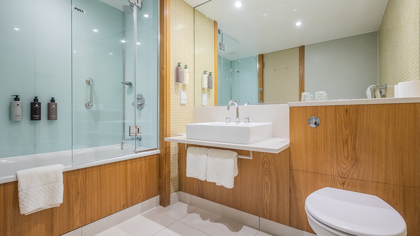Bathroom with a bath tub and wooden panelling