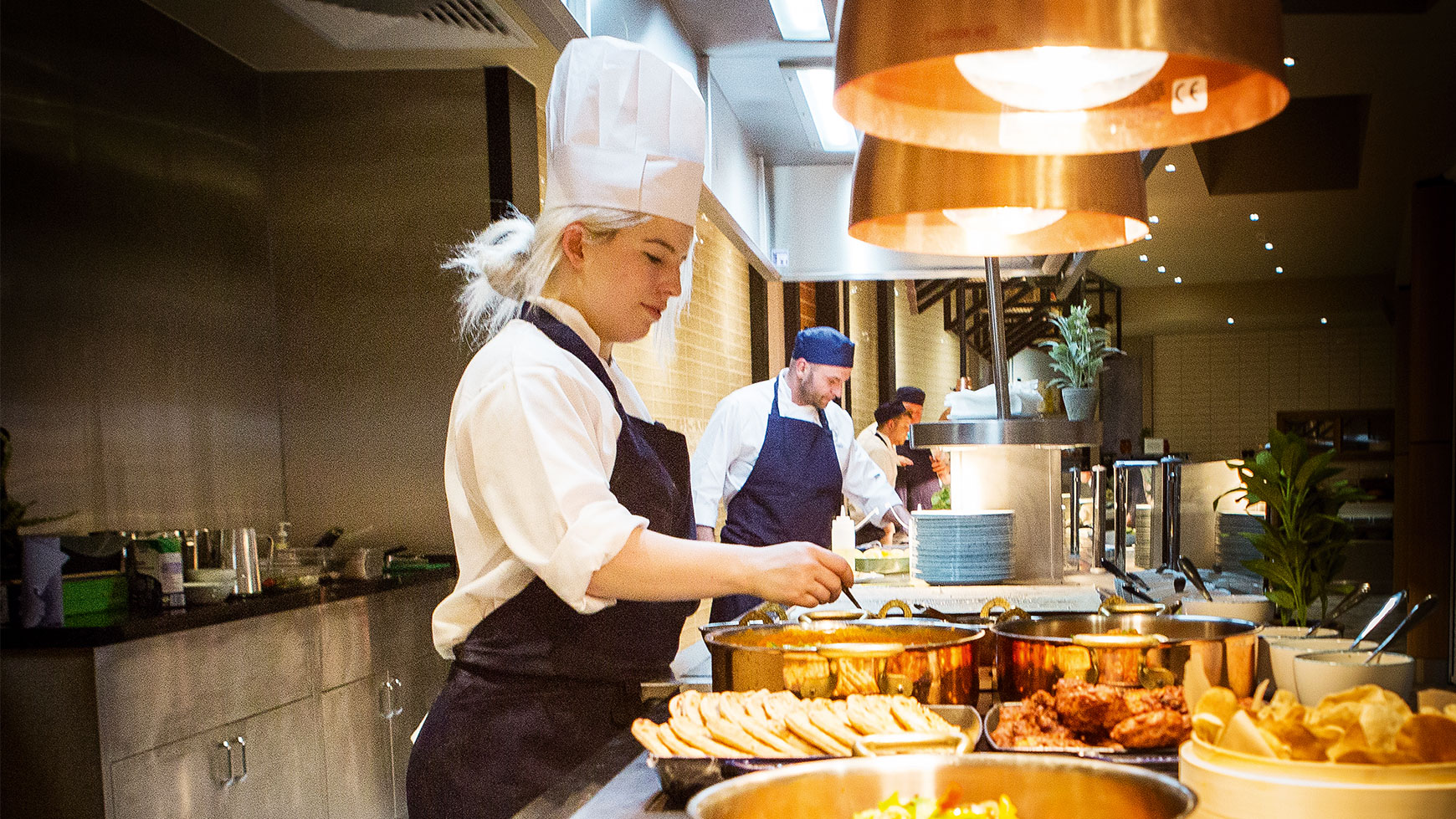 Chef flipping a flat bread and smiling behind a griddle