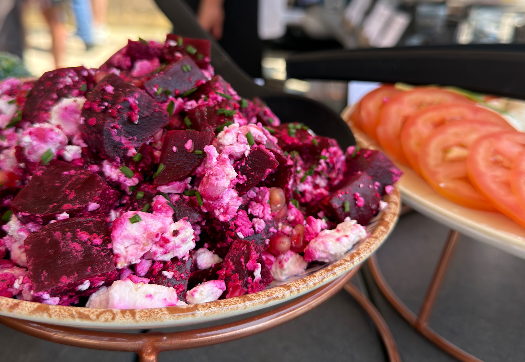 Close-up of a vibrant beetroot salad with crumbled cheese and herbs, served as part of a Big Green Egg dining selection.