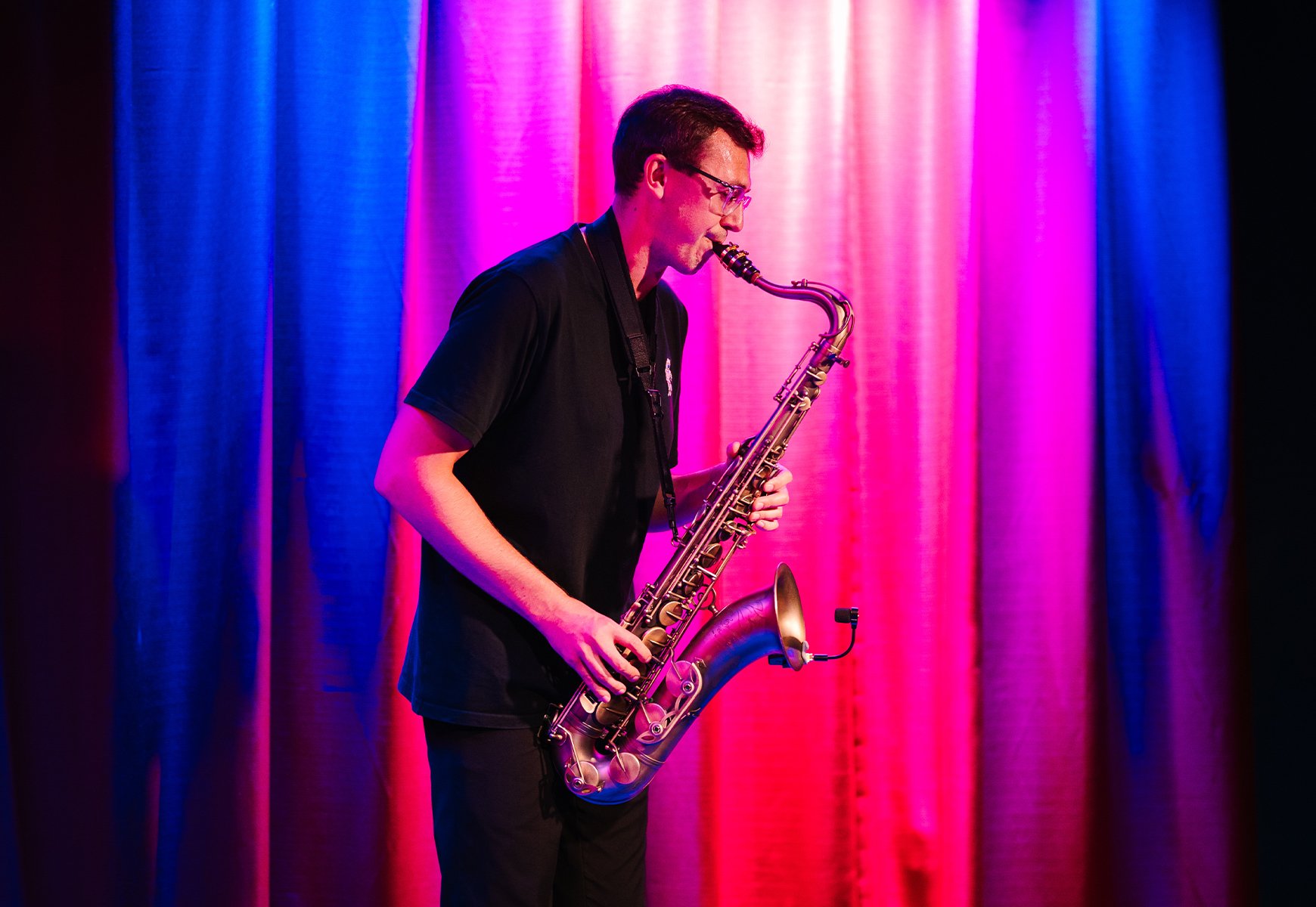 Saxophone player playing in the street as the sun sets