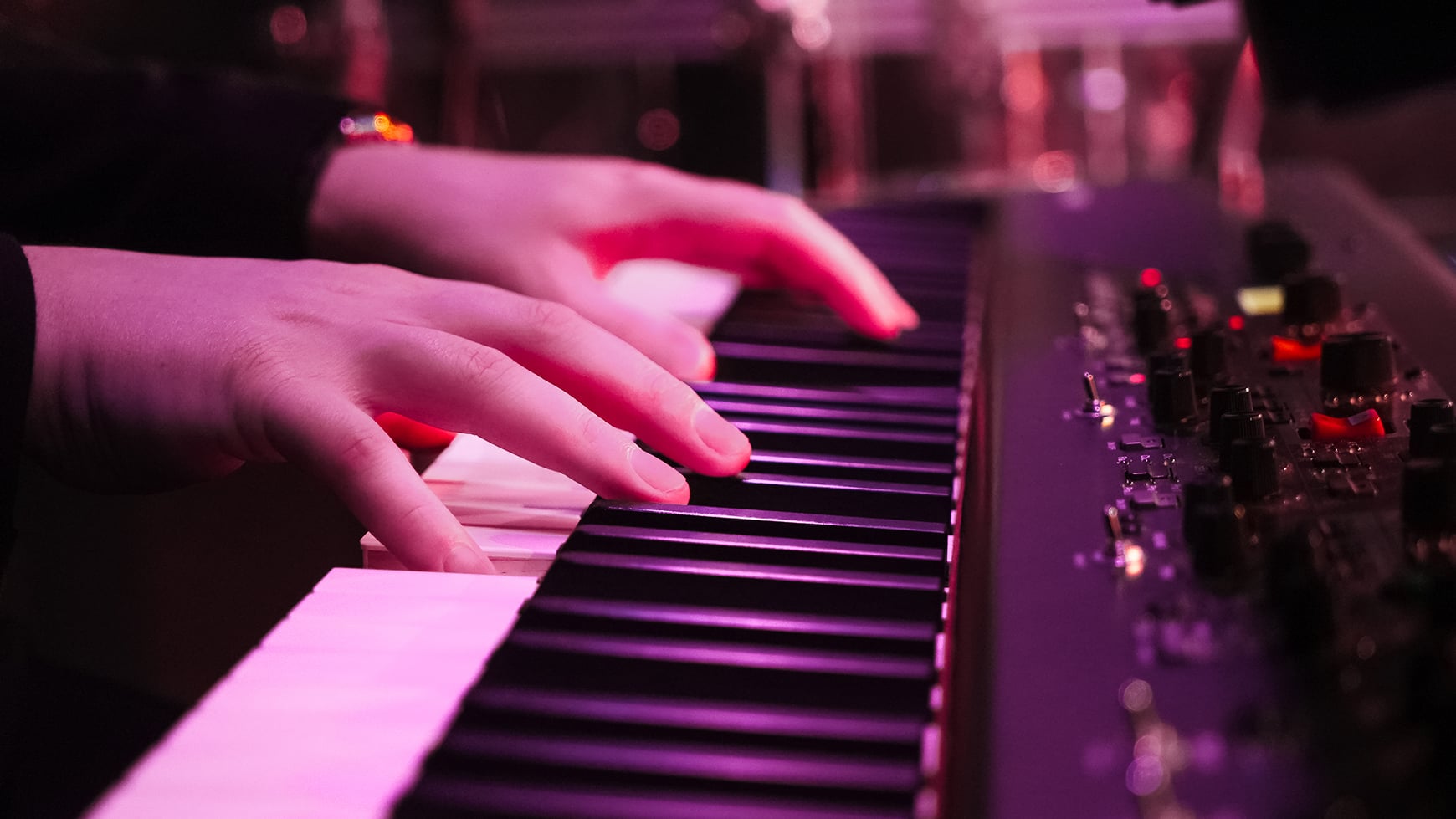 Close up of someone's hands playing a piano