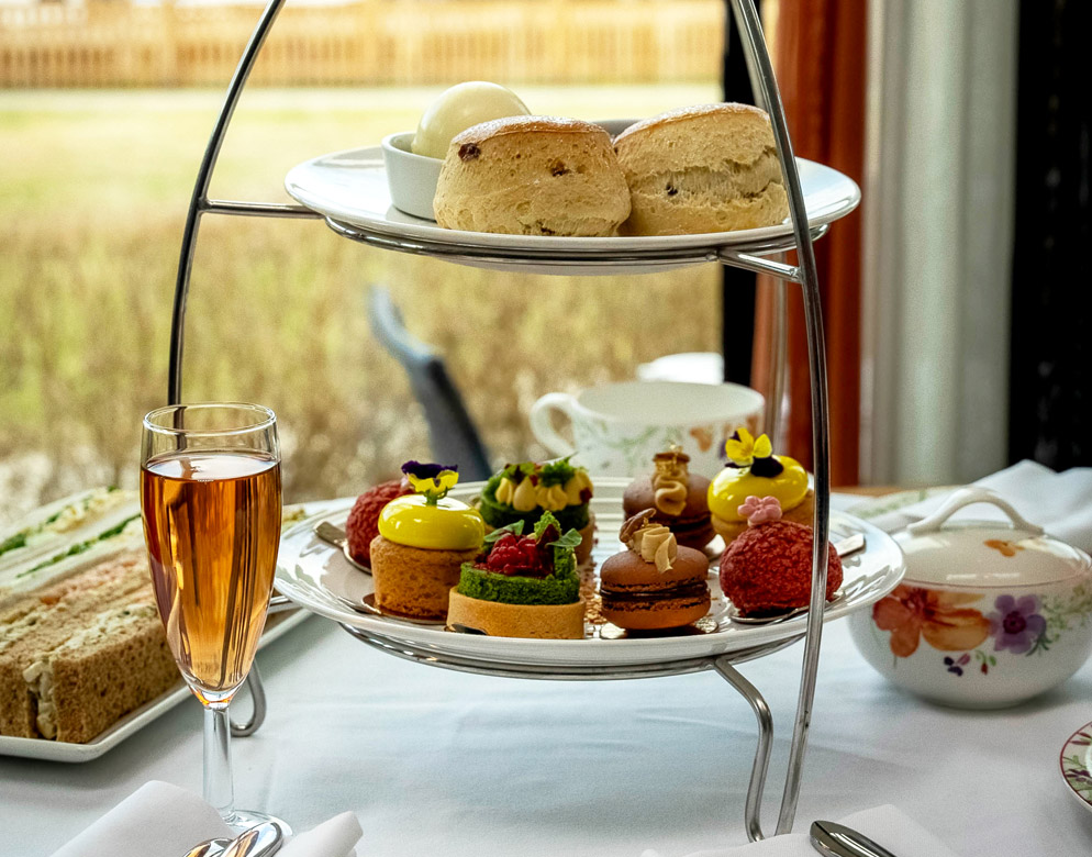 Afternoon tea served elegantly at Warner Hotels, featuring fine china and delectable pastries.