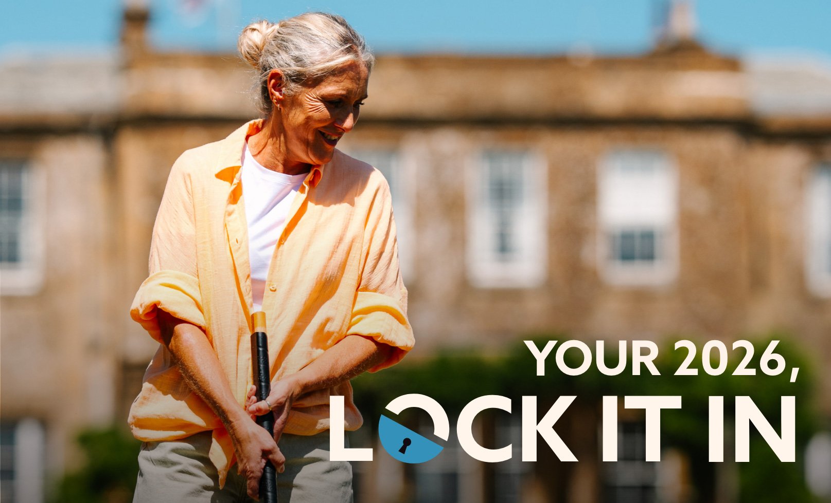 A person in a light orange shirt holds a golf club in front of a Cricket St. Thomas hotel building, with the text
